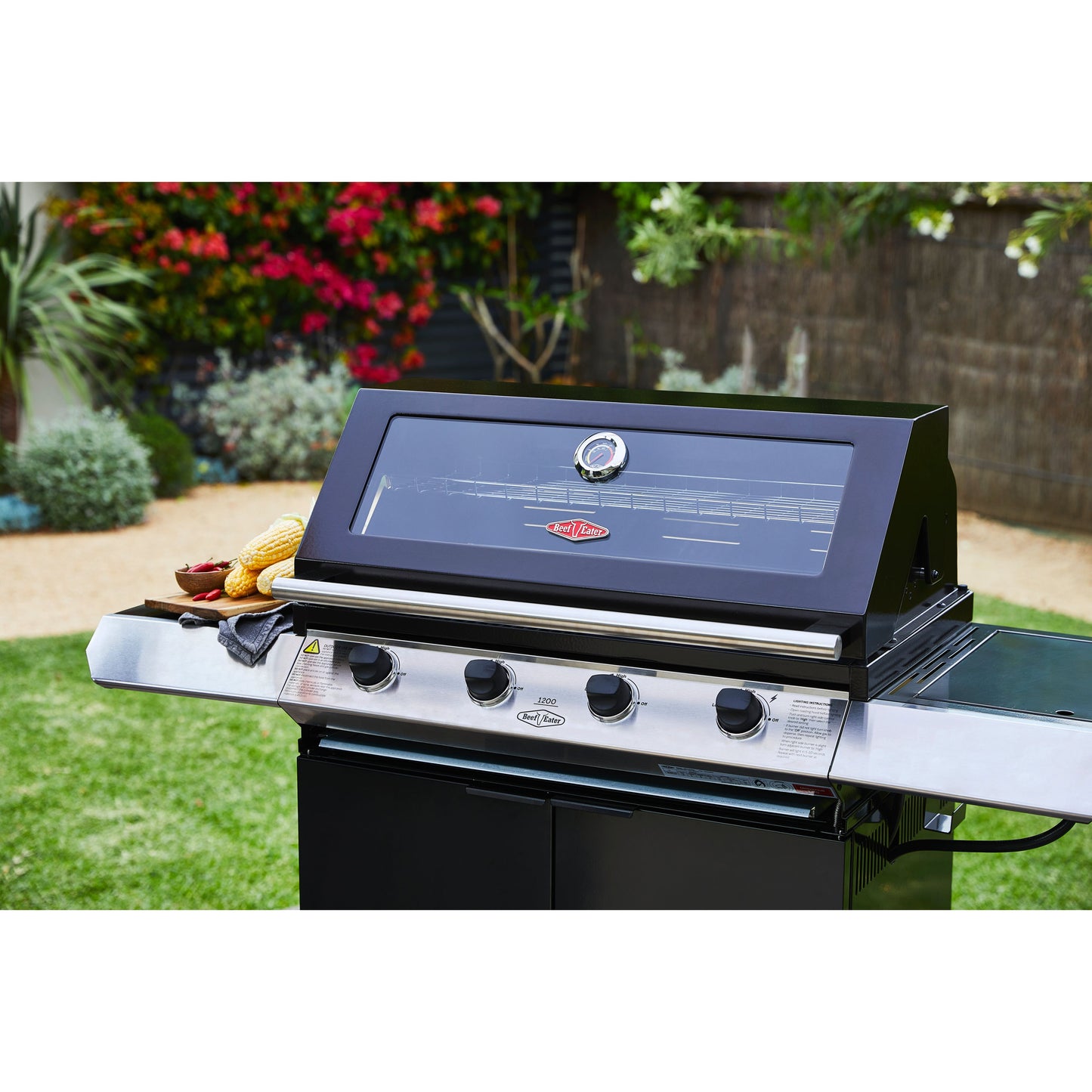 Beefeater 1200E Series 4 Burner Gas BBQ with Trolley and Side Burner in a garden with the hood closed close picture