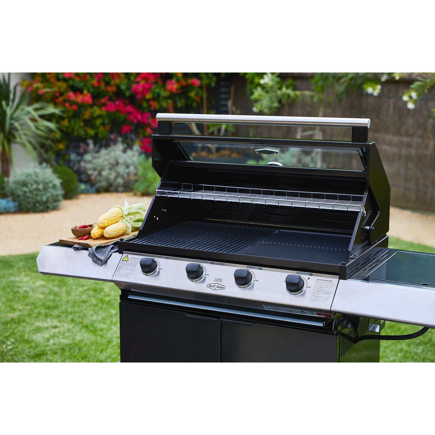 Beefeater 1200E Series 4 Burner Gas BBQ with Trolley and Side Burner in a garden with the hood open close picture